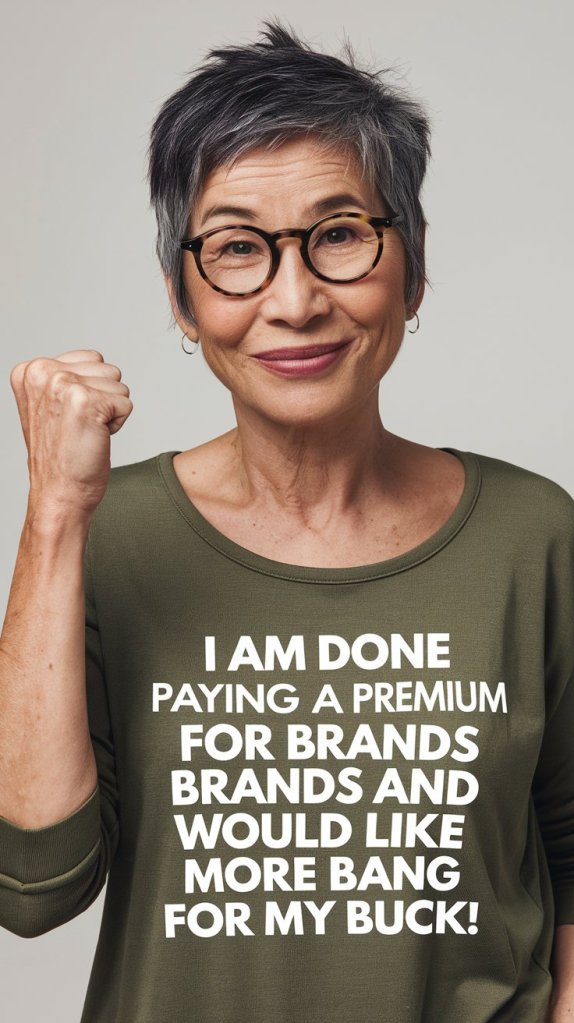 Person with short gray hair and glasses smiling at the camera, wearing an olive green shirt with the text 'I AM DONE PAYING A PREMIUM FOR BRANDS AND WOULD LIKE MORE BANG FOR MY BUCK!'
