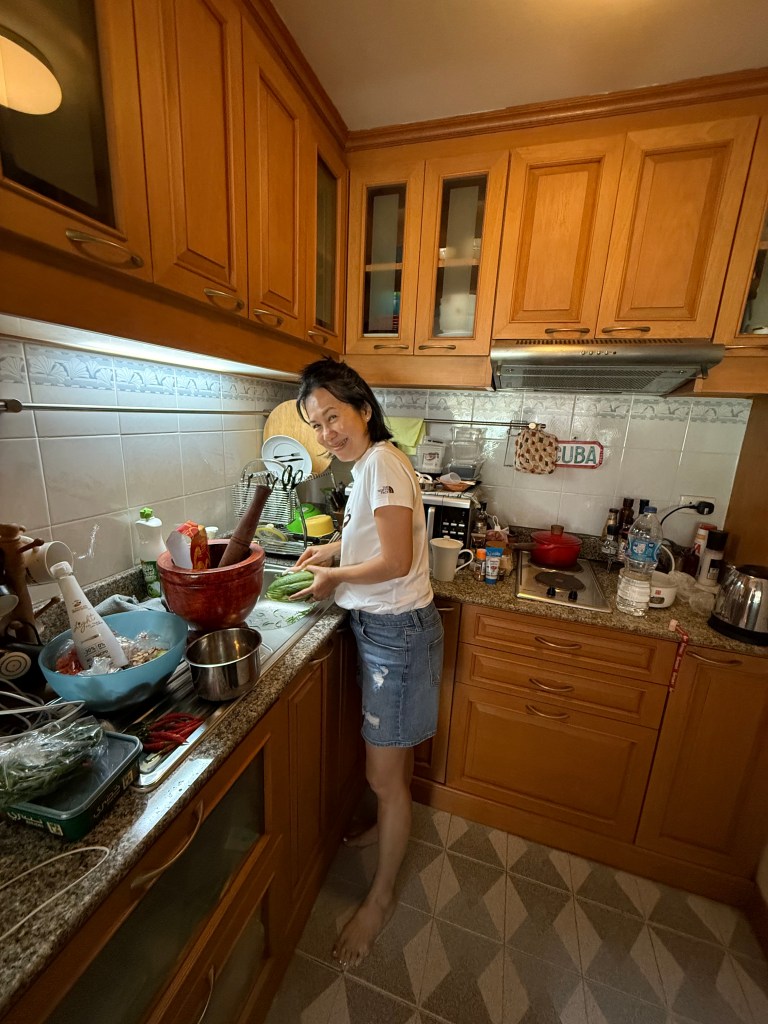 A person preparing ingredients in a modern kitchen, surrounded by various dishes and cooking utensils.