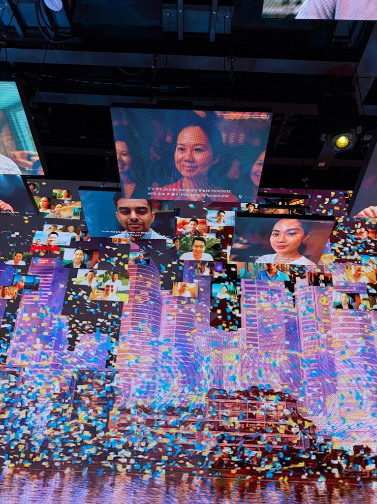 A vibrant display featuring multiple digital screens showcasing diverse avatars and faces with a backdrop of a city skyline, enhanced by dynamic confetti effects.