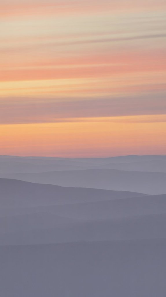 A serene landscape showcasing rolling hills in soft hues of purple and pink, with a gentle gradient in the sky during sunset.