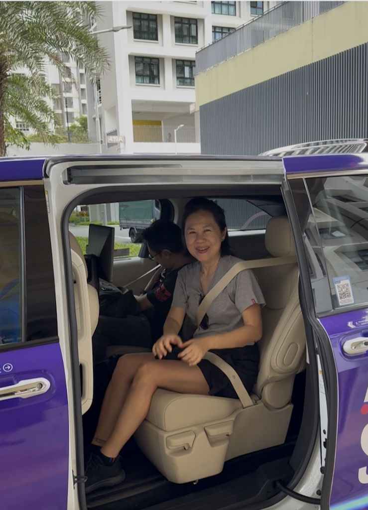 Jane Bay smiling while seated inside a purple ComfortDelGro autonomous shuttle, demonstrating the passenger experience during the Punggol trial.
