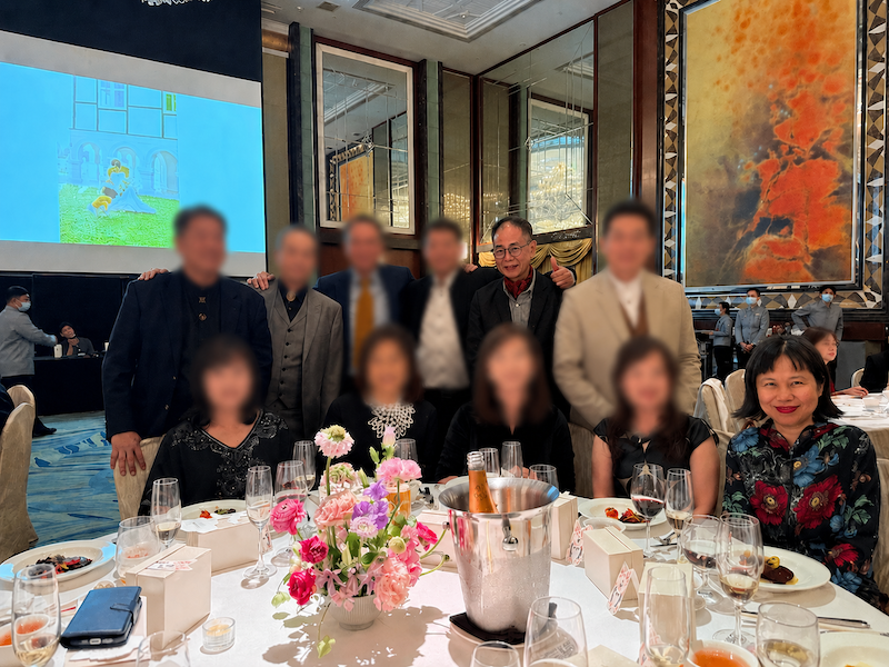 The creator of Ageisano sitting and smiling harmoniously at a wedding banquet dinner table with her ex-husband and his current wife nearly 20 years after their divorce.